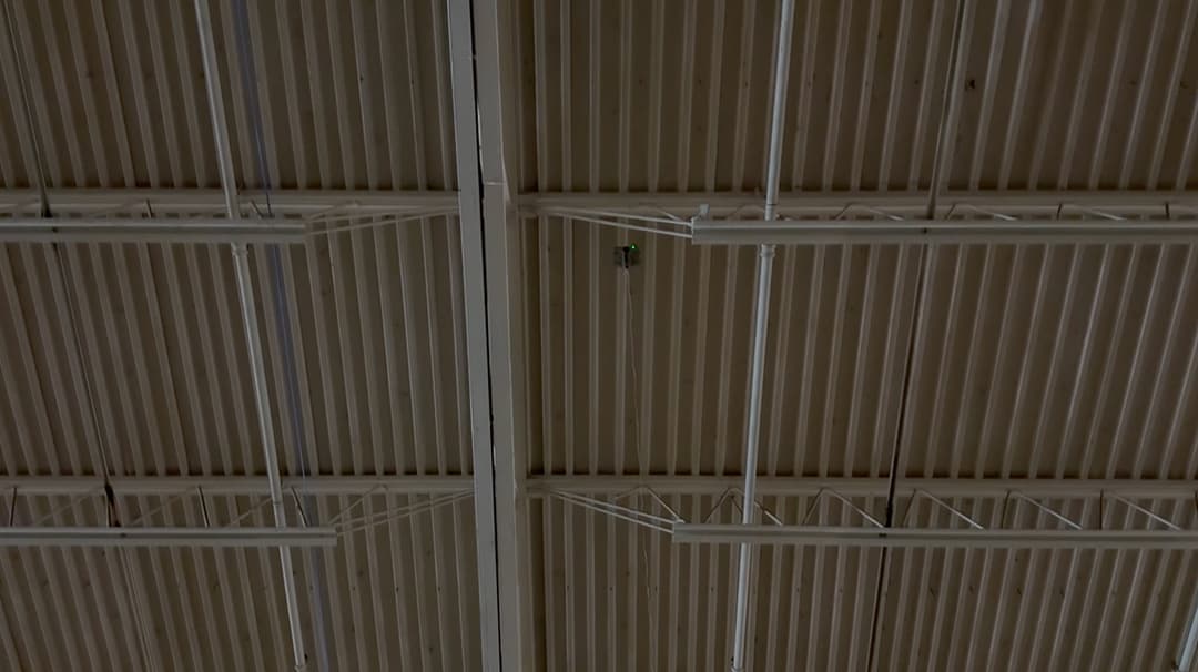 High angle view of warehouse roof trusses during initial network cable path planning