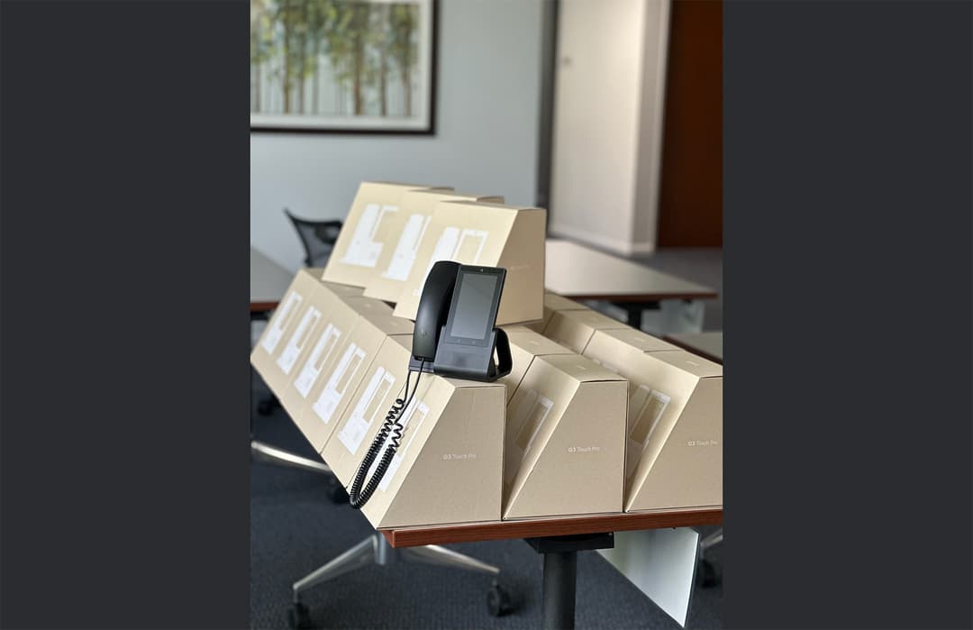 A large scale inventory deployment of UniFi Talk Touch phones ready for corporate telecommunications installation.