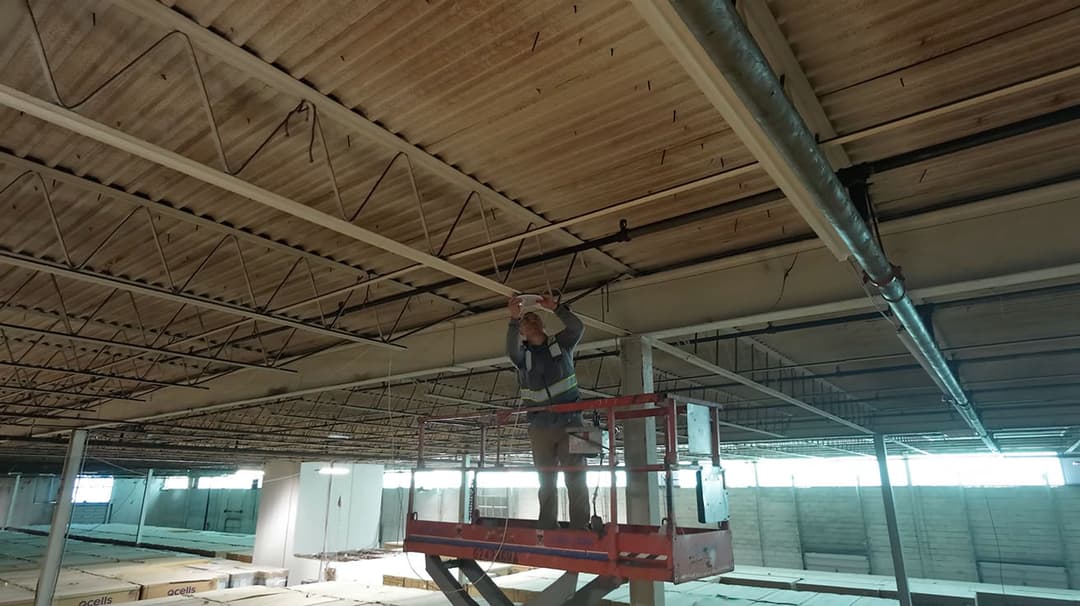 YesTechie technicians on a scissor lift mounting a UniFi Wi-Fi 7 access point on the ceiling