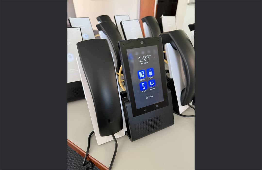 Close up of a UniFi Talk enterprise IP phone screen displaying native integration with physical security and door access applications.