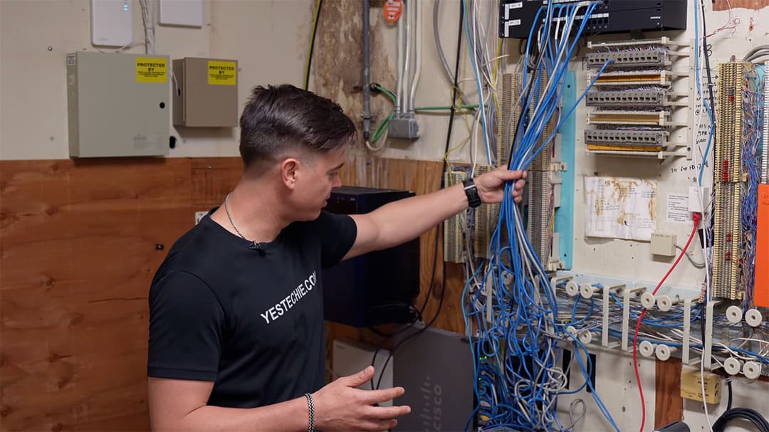Messy server room with old Cat5 cables and phone lines before the network upgrade.