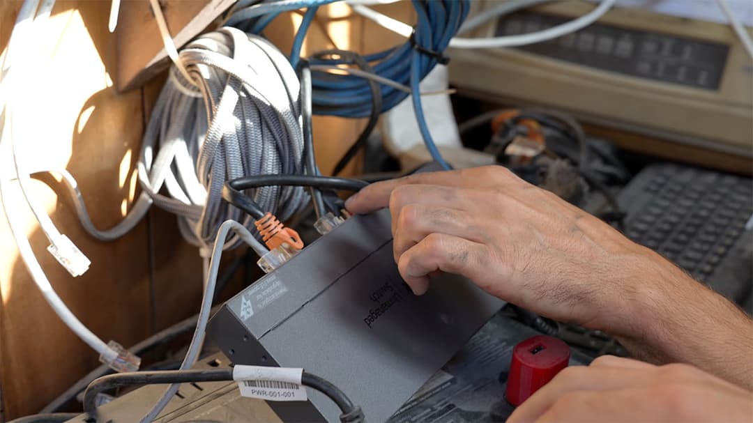 Tangled legacy network wiring causing connectivity issues at a recycling plant.