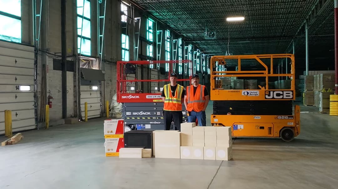 YesTechie technicians on site with a scissor lift deploying a warehouse network